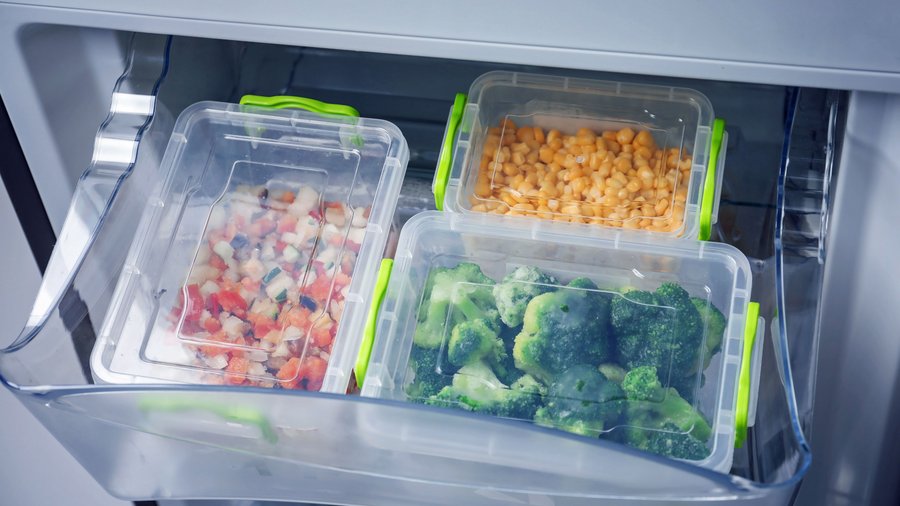 Behälter mit Gemüse im Tiefkühlfach